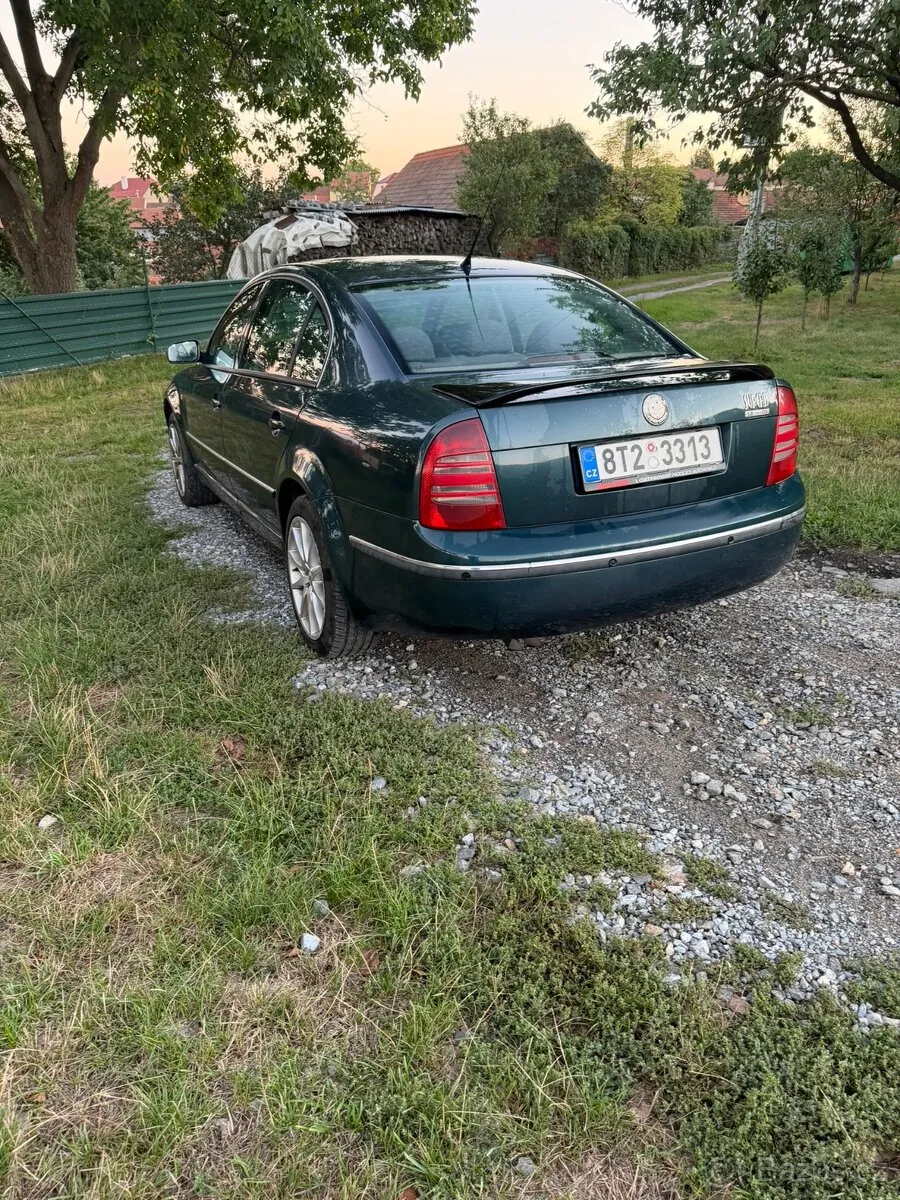 Škoda Superb stojí za soumraku na polní cestě